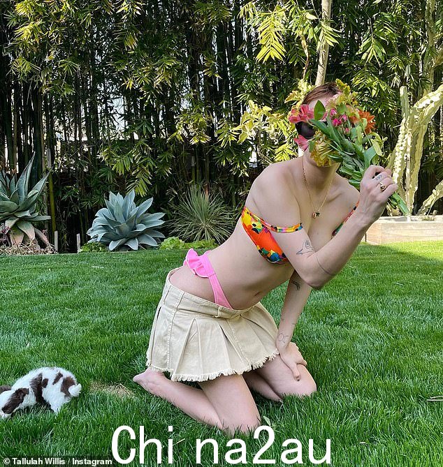 不可思议:她拿着一束鲜花跪在她的花园里,用一条米色牛仔溜冰裙搭配这身裙子