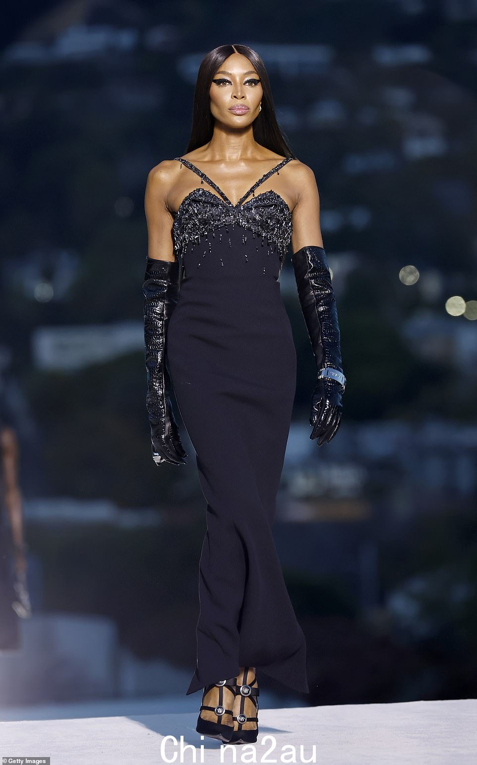 一个传说:Naomi Campbell 身穿黑色紧身礼服,配以黑色宝石和及肘手套,看起来容光焕发
