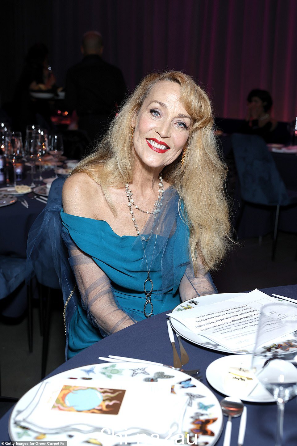 永不过时的偶像:66 岁的杰里·霍尔 (Jerry Hall) 身着蓝色高低裙,包裹着她合身的身材,看起来很迷人在所有正确的地方。” class=