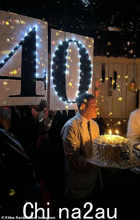 一张快照中有一个男人为姐妹们拿着一个大生日蛋糕
