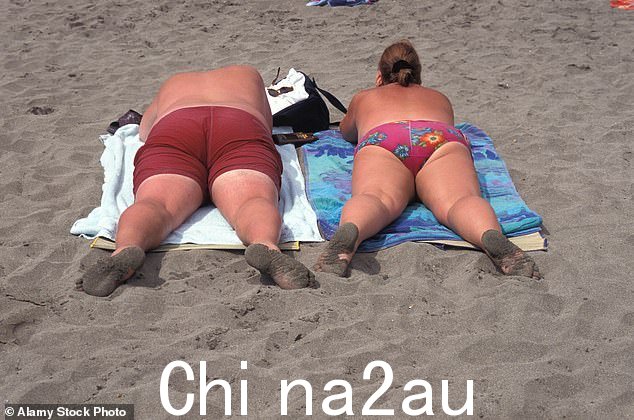 英国度假者在西班牙特内里费岛的海滩上晒日光浴