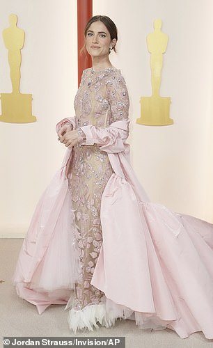 M3GAN 校友 Allison Williams,34 岁,她的粉色套装太多了——她选择了一件底部有俗气白色荷叶边的华丽连衣裙,搭配一件巨大的外套