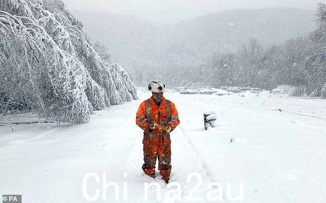 网络铁路工人在峰区 Grindleford 的铁路头顶上方高达八英寸的积雪中