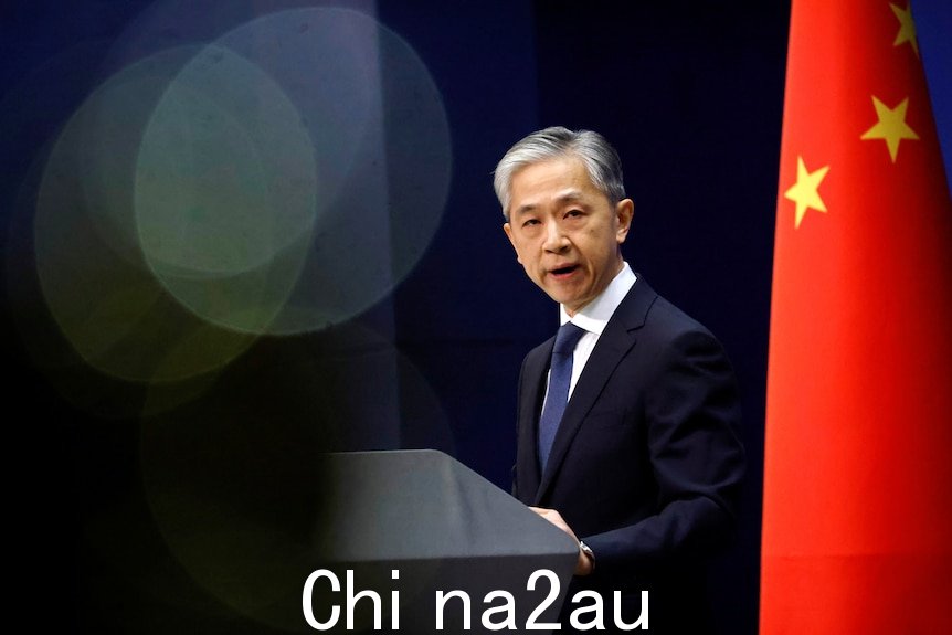 中国外交部发言人汪文斌在 2020 年的新闻发布会上讲话，两侧是中国国旗。