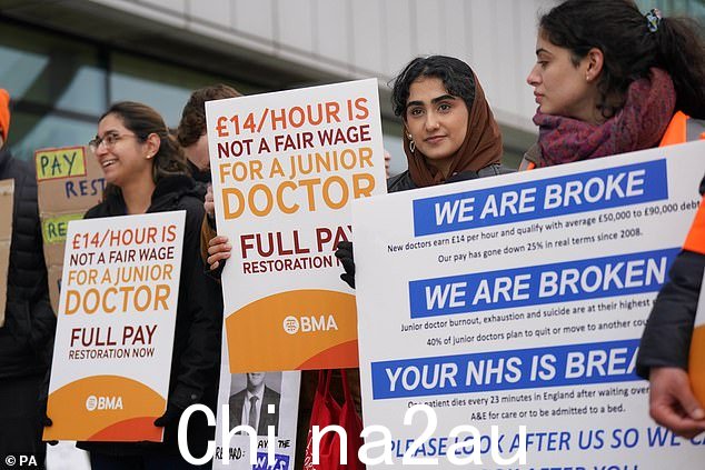 英国医学会要求初级医生“恢复薪酬”,他们约占医疗劳动力的 45%。图为 3 月 15 日在伯明翰伊丽莎白女王医院外罢工的 NHS 工作人员