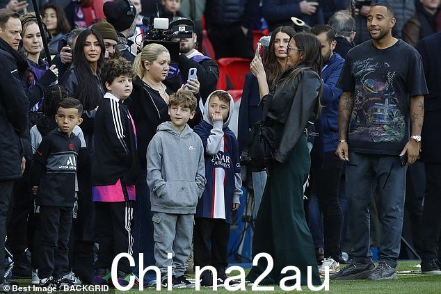 保持真实:可以看到 Kim 站在 t 成员旁边he public at the side of the pitch