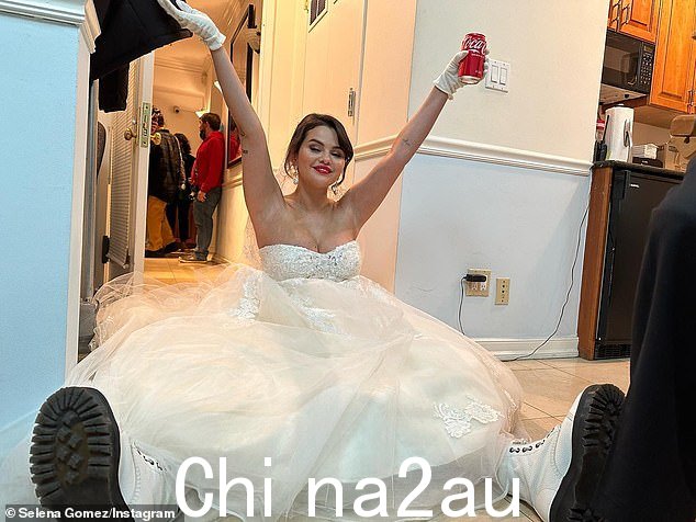Coke break: Selena 穿着白色靴子和一罐可乐在镜头前放松