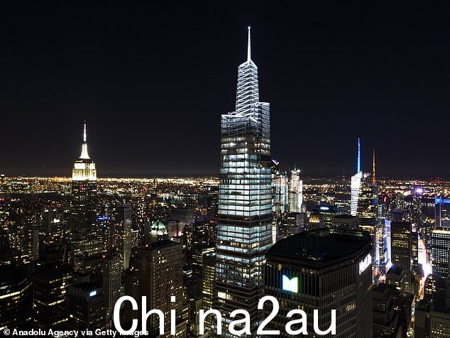 摩天大楼在晚上被点亮,帝国大厦在图像的左边,时代广场的灯光在后面