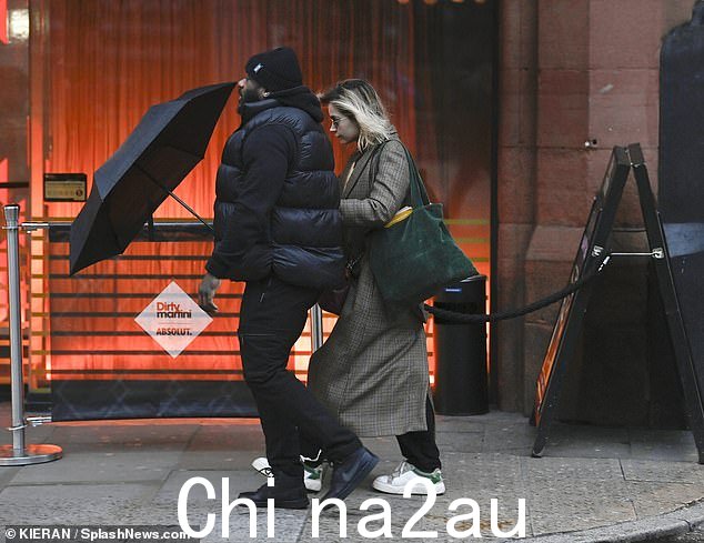 低调:Jenna 一直低着头,在守卫旁边散步时用一把大雨伞遮雨