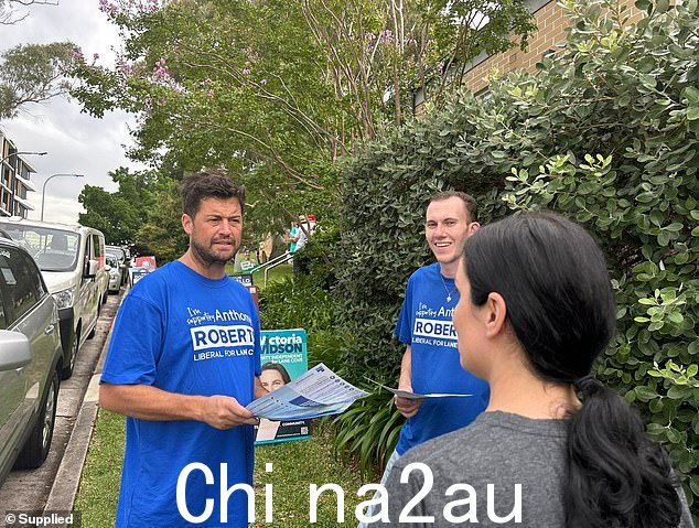自由党志愿者 Ben Collins 和 Rory Burke(身穿蓝色 T 恤)周四早些时候抵达 Lane Cove 议会会议厅外,将 Anthony Roberts 的海报放在最佳位置。Collins 先生(左)拍摄竞争对手志愿者 Noel Plumb 据称行为激进