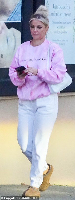 已连接:当她离开钉子处时,Ariana 的眼睛盯着她的 iPhone,似乎在发短信