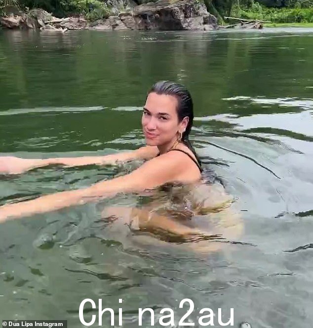 Quick dip:在她的假期照片中还有一张她穿着黑色两件套跳入湖中的照片