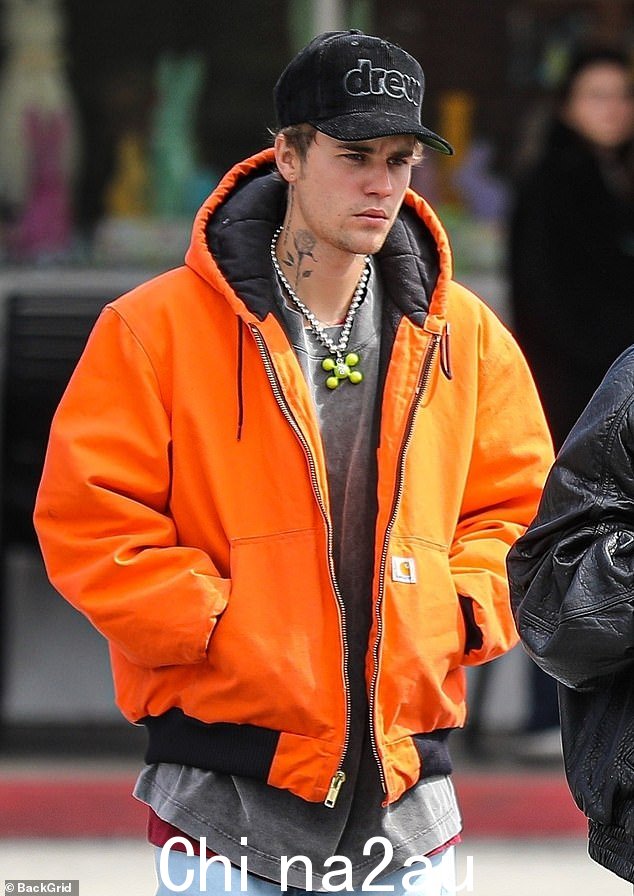 叠穿:Justin 在深灰色 T 恤上穿了一件亮黑橙色 Carhartt 连帽衫,而 Hailey 选择了一件超大号皮夹克和一条相配的裤子