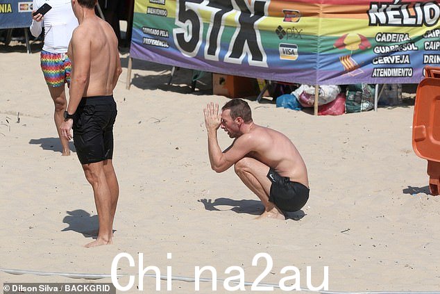 休息一下:克里斯在巴西的海滩上休息时被看到蹲在沙滩上