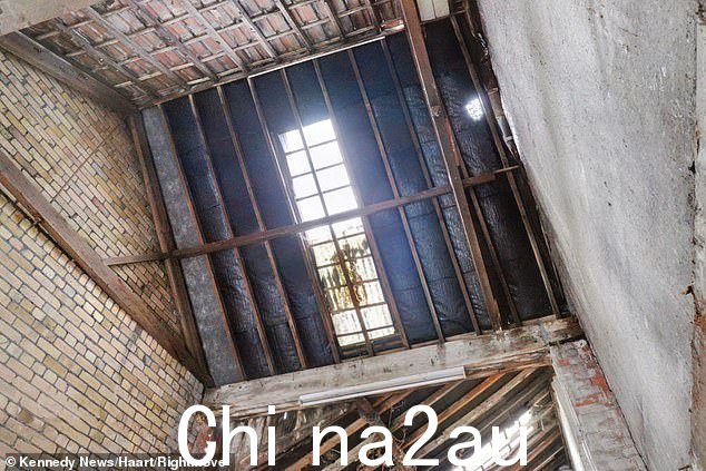 照片显示光秃秃的砖墙一直延伸到未完工的屋顶,中间有一个巨大的洞
