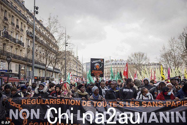 抗议者在巴黎抗议法国总理杰拉尔德·达尔马宁的庇护和移民法案期间举着写着“反对达尔马宁法”的横幅。 100%