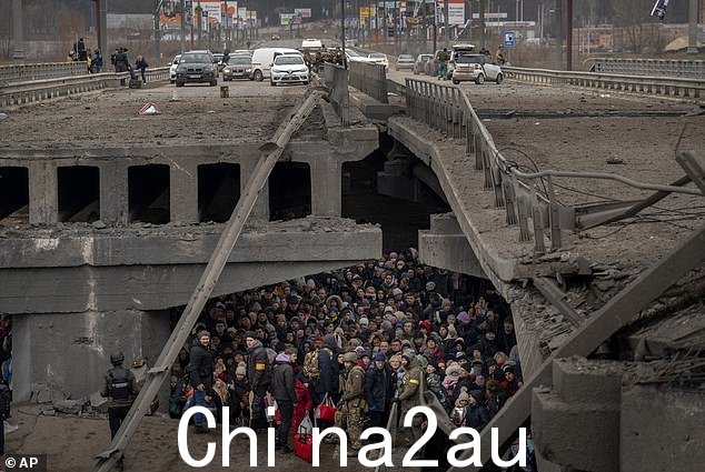 俄罗斯军队在战争的第一个月未能夺取基辅后从基辅撤退,士兵和记者在周边城镇发现了可怕的景象,例如伊尔平和它的邻居布查。图为:去年 3 月 5 日,平民在逃离俄罗斯前进部队时躲在 Irpin 一座被毁的桥下