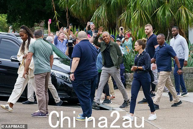 美国前总统奥巴马(中)离开蝙蝠馆后向围观者挥手致意她周一在巴尔莫勒尔的展馆