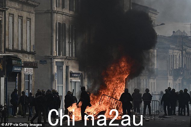 图:警察在波尔多站岗时,骚乱者绕过高耸的火堆