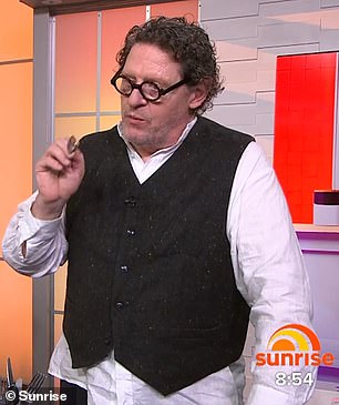 他穿着白色衬衫和黑色背心,戴着一副圆框眼镜,与共同主持人 David Koch 和 Natalie Barr 聊天