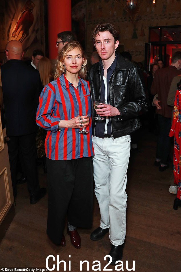 Style: 在他旁边,Imogen 身穿红蓝条纹衬衫和宽松的黑色长裤,在人群中脱颖而出