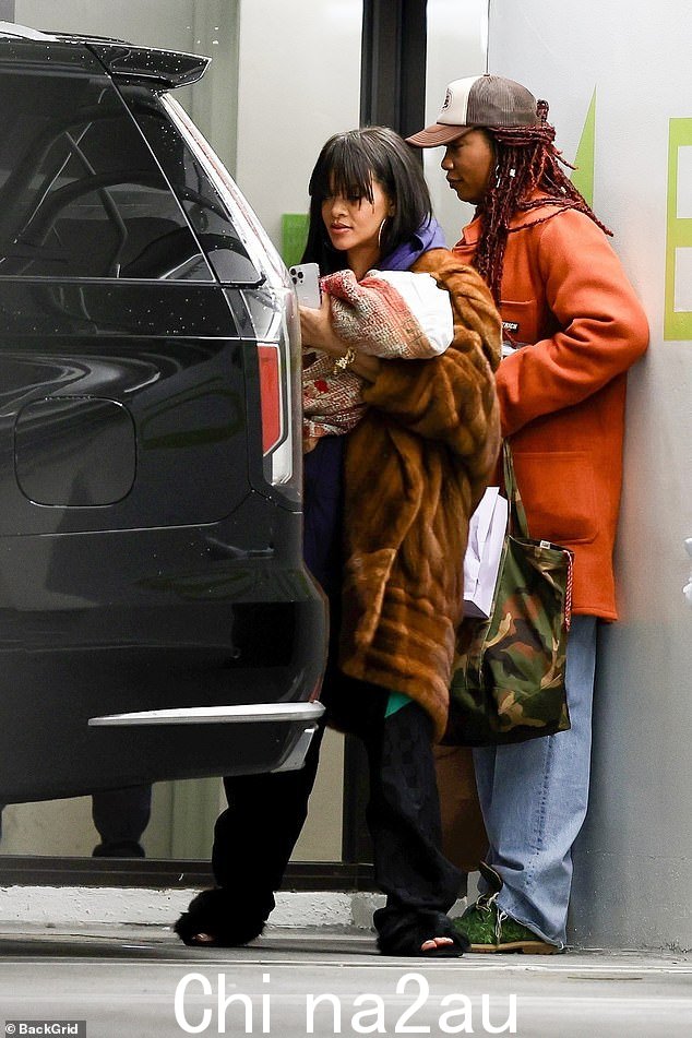 舒适:为了跑腿,蕾哈娜 (Rihanna) 为她的运动衫和外套搭配了宽松的黑色裤子和毛茸茸的拖鞋