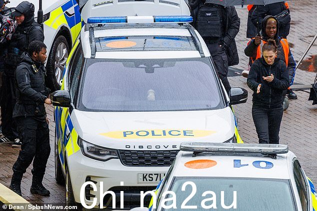 剧情:随着剧情的继续拍摄,片场停了一排警车,剧组都穿着雨衣