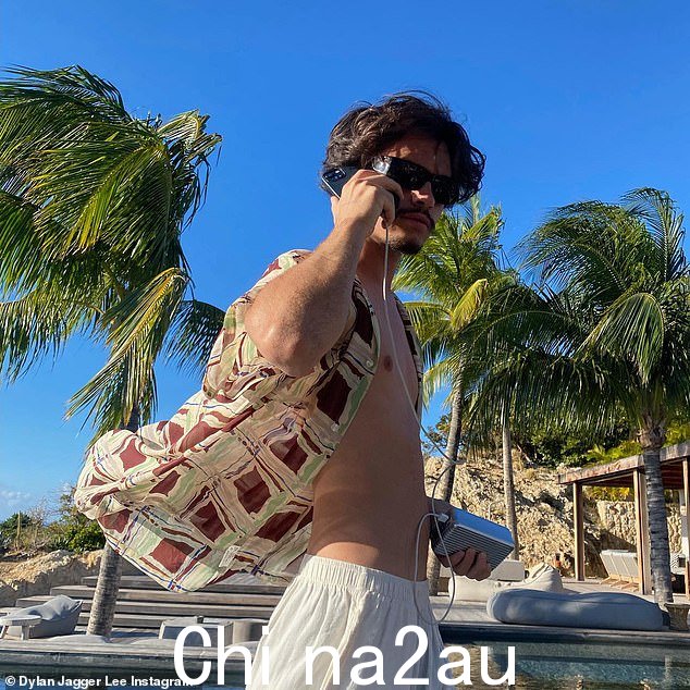 在天堂闲逛:周五,他在手机上贴了一张自己的照片,手机插在便携式充电器上。他穿着一件敞开的衬衫,露出健美的胸部,戴着墨镜,穿着宽松的白色裤子