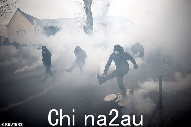 雷恩的蒙面抗议者在示威冲突中对催泪瓦斯作出反应,这是全国罢工和抗议法国政府养老金改革的第十一天的一部分