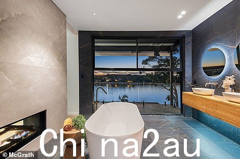 在楼上,主卧室有一件名人级的步入式长袍,还有一个精致的套间,从地板到天花板都装饰着金色纹理的黑色大理石瓷砖,有一个双人间。双面壁炉和独立浴缸