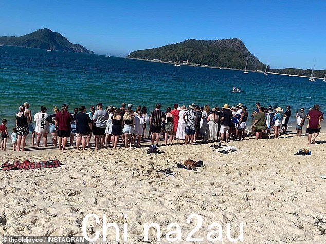 家人和朋友于 3 月 19 日聚集在浅滩湾,在凯特琳的记忆中将鲜花放入海洋