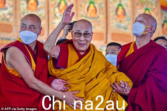 在这张拍摄于 2022 年 12 月 29 日的档案照片中,西藏精神领袖达赖喇嘛在菩提迦耶时轮金刚法场开示的第一天挥手致意
