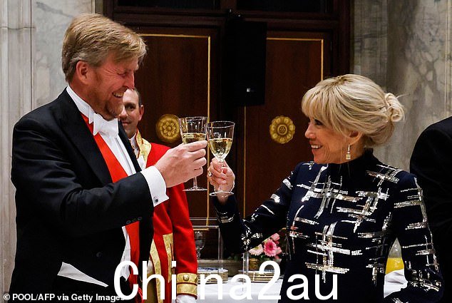 Willem-Alexander 和 Brigitte Macron 在享用国宴时愉快地互相举杯