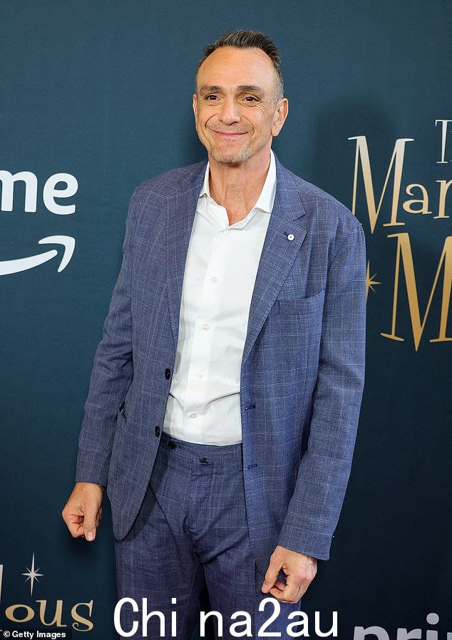 庄严:Hank Azaria 也选择了柔和的蓝色西装,而不是白色纽扣西装,但他的套装以微妙的格子图案为特色