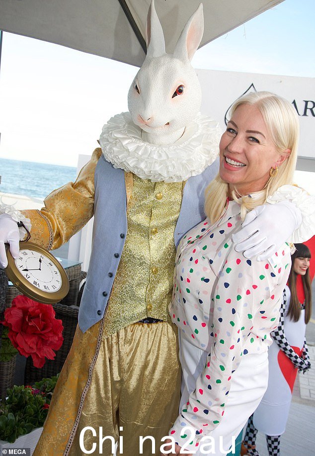 派对时间:Denise 在一位拉比旁边微笑着参加爱丽丝梦游仙境主题派对t mascot