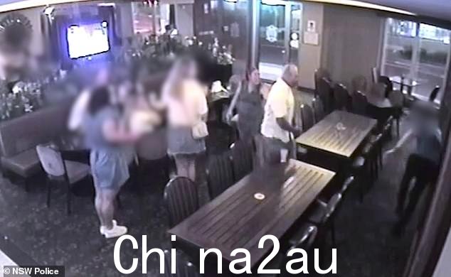 保安人员被推倒在墙上(如图,最右边),然后另一名身穿蓝色连衣裙和白色鞋子的女士走近该男子,将他带走