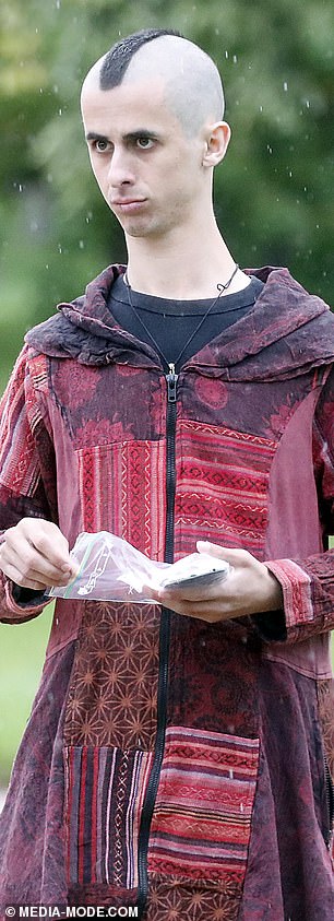 一个男人用一个自封袋让他的手机在雨中保持干燥