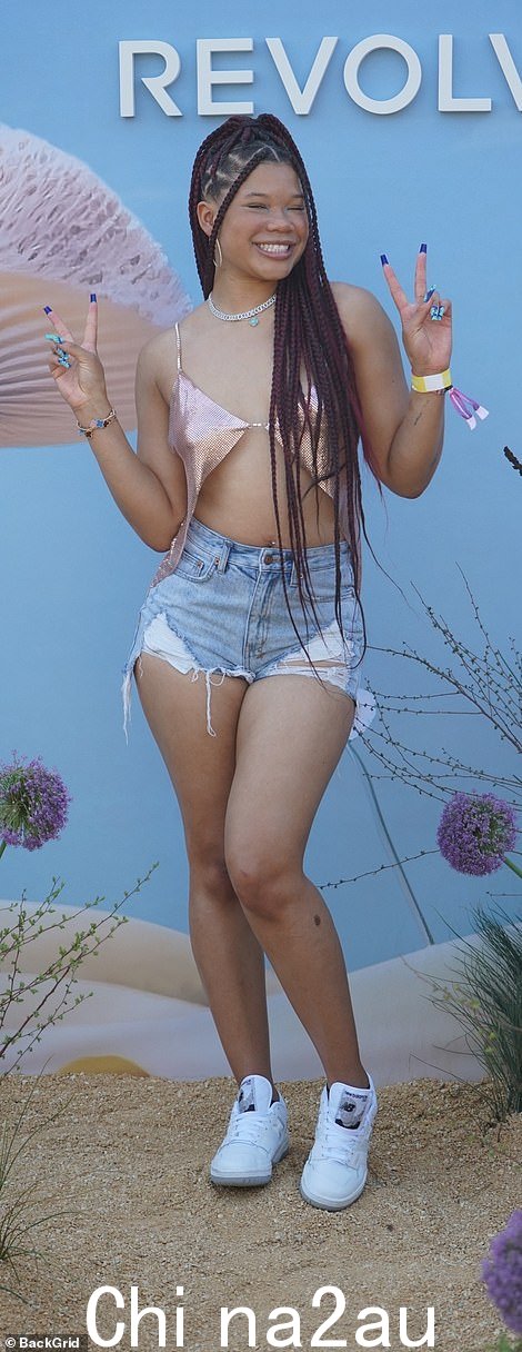 年轻风格:Storm Reid,19 岁,穿着高腰牛仔短裤和暴露的金属色面料上衣