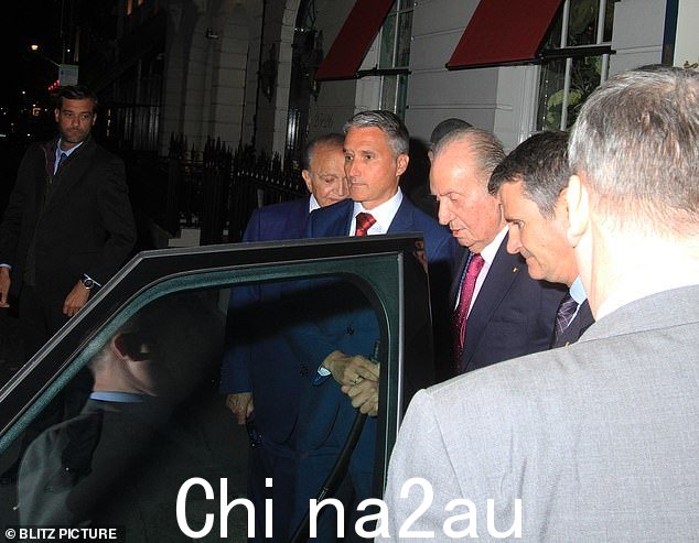 Juan Carlos 晚上在私人会员俱乐部外出时身着海军蓝西装,打着粉色领带