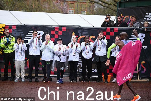 英国选手 Mo Farah(右)在今天于伦敦市中心举行的 2023 年伦敦马拉松比赛中以男子组第 9 名完赛后受到鼓掌