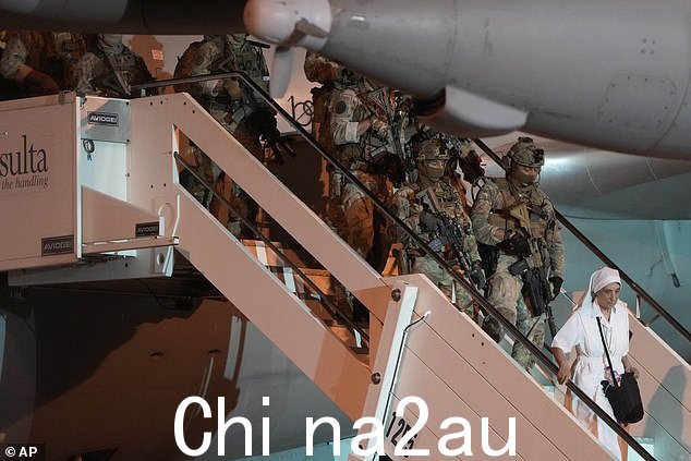 一个修女跟着意大利陆军士兵下船4 月 24 日,一架载有从苏丹撤离的意大利公民的空军飞机降落在罗马的钱皮诺军用机场