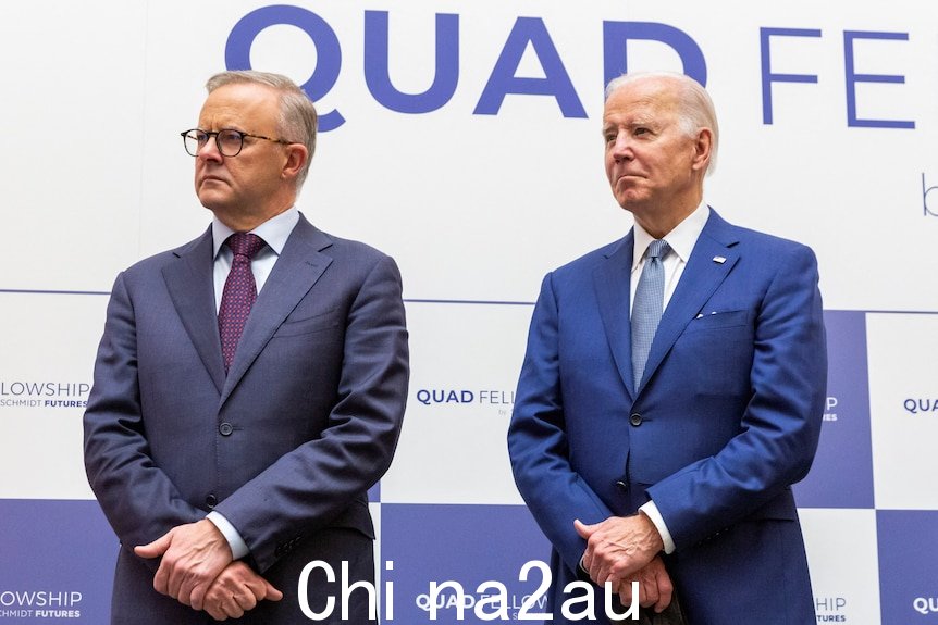 Anthony Albanese 和 Joe Biden 在 Quad 活动标牌前并排站立。