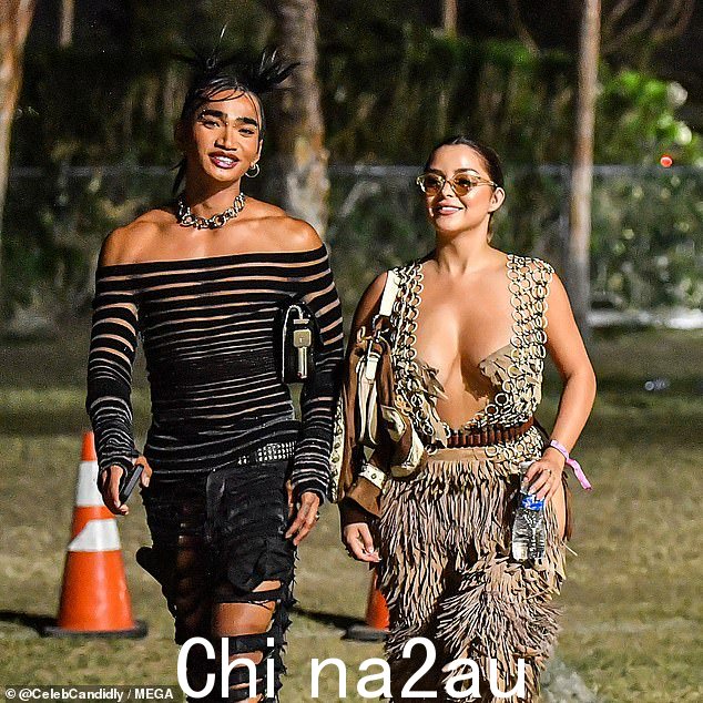 热门话题:这位 28 岁的模特在参加加利福尼亚州印第奥的音乐节时,穿着一件由箍和流苏组成的深 V 迷彩连身裤,露出了乳沟