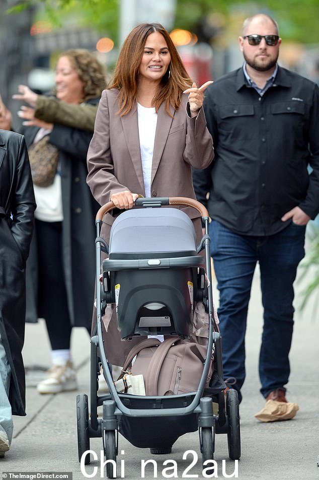 外出走动:这位 37 岁的模特与传奇音乐家 John Legend 结婚,周四在纽约享受时光,尽职尽责地推动了她四个月- old baby girl's stroller down the street