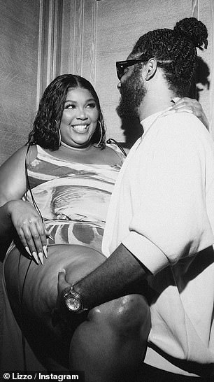 Mingling:专业镜头捕捉到 Lizzo 在坐在长餐桌的头部之前与朋友聊天和大笑
