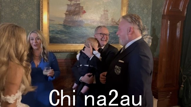 总理安东尼·艾博年在周六的婚礼上抱着这对新婚夫妇的儿子奥托。图片:新闻集团-独家。