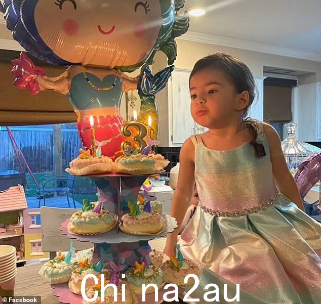 图中贝拉在她三岁生日派对上吹灭蜡烛