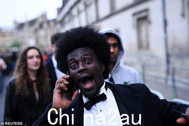 牛津:在五一节庆祝活动期间,当人们在马格达伦桥上等待合唱团时,狂欢者的反应