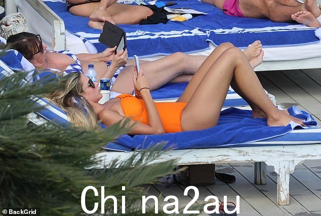休息时间:当她在阳光下放松并在游泳池中畅游时,Zara 在橙色数字中展示了她华丽的曲线