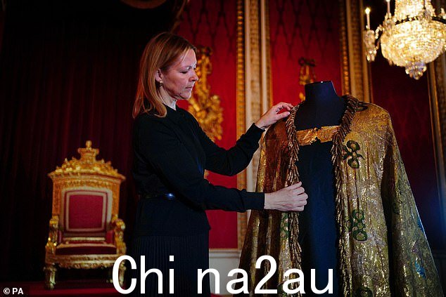皇家斗篷(如图)是加冕礼服的一部分(此处,皇家收藏信托基金的国王艺术品副测量员 Caroline de Guitaut 正在调整服装)